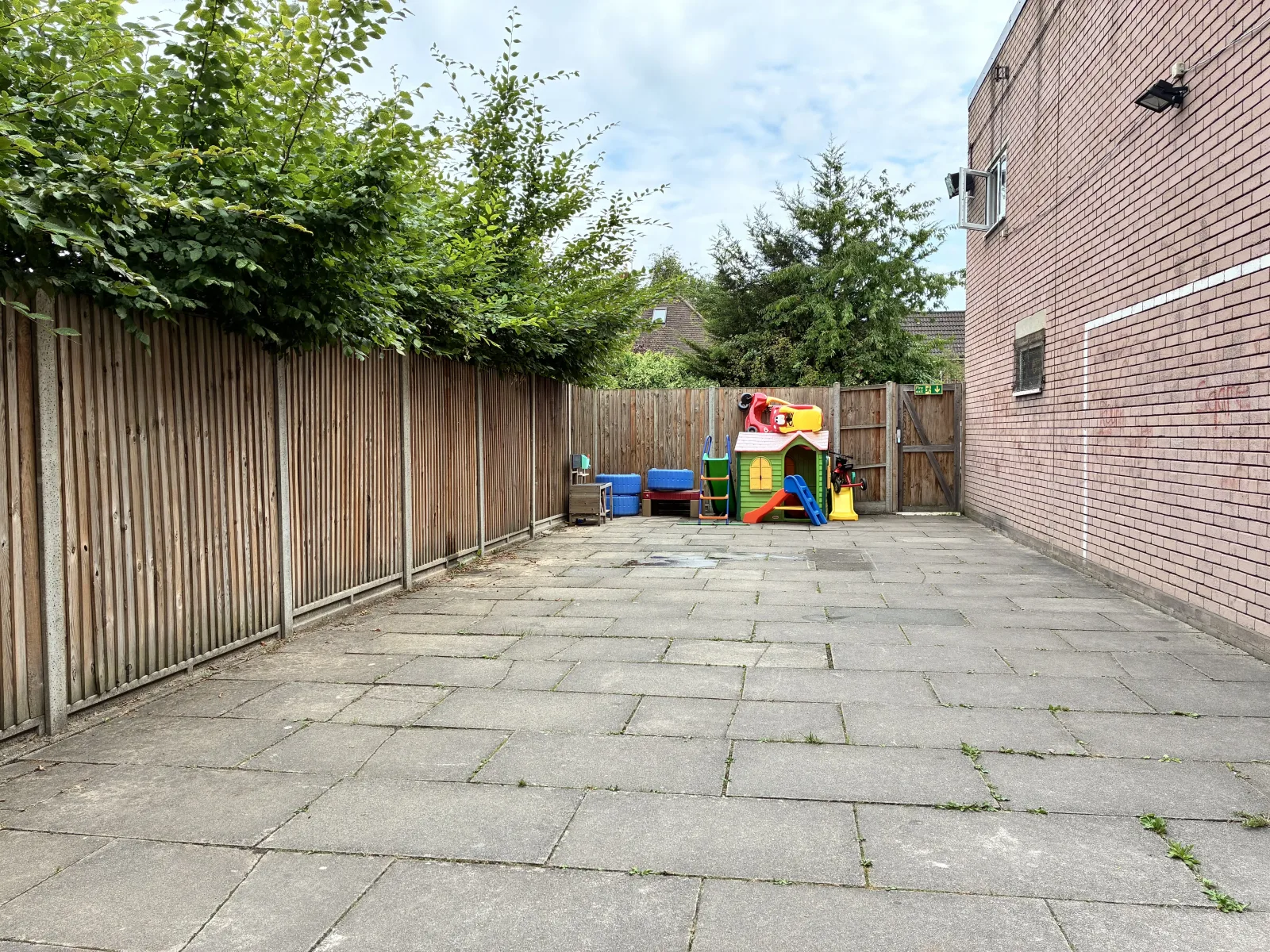 The Centre's enclosed outdoor area with a children's playhouse